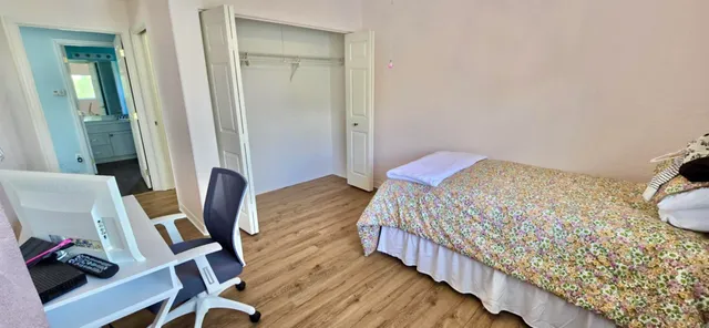 a front view of a house with a tree and wooden fence