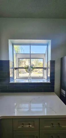 a living room with a large window and swimming pool