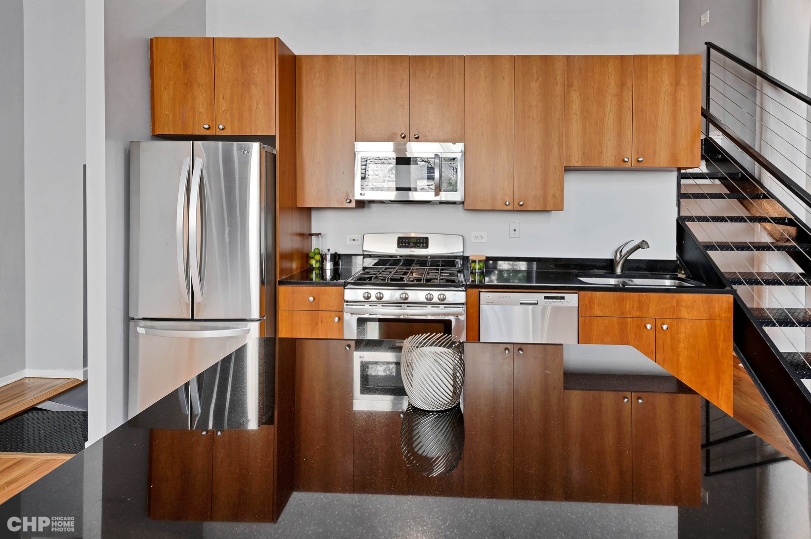 2000 South Michigan Avenue, Unit 107 Chicago, IL 60616 - Photo 10 of 30 a kitchen with stainless steel appliances granite countertop a refrigerator a stove and white cabinets with wooden floors