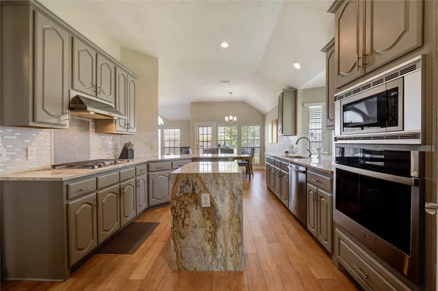 a kitchen with stainless steel appliances granite countertop lots of counter top space a stove and cabinets