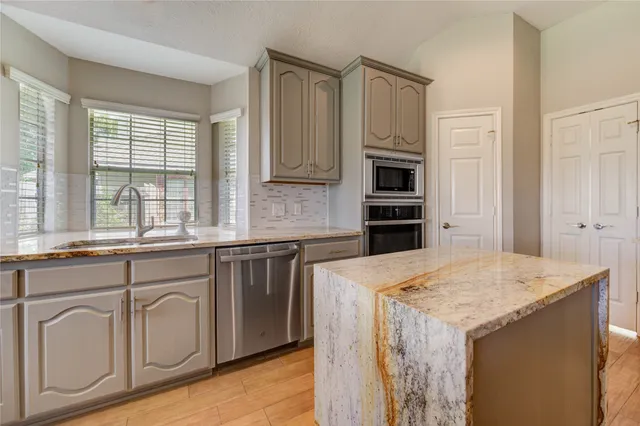 a kitchen with stainless steel appliances granite countertop a stove and a refrigerator