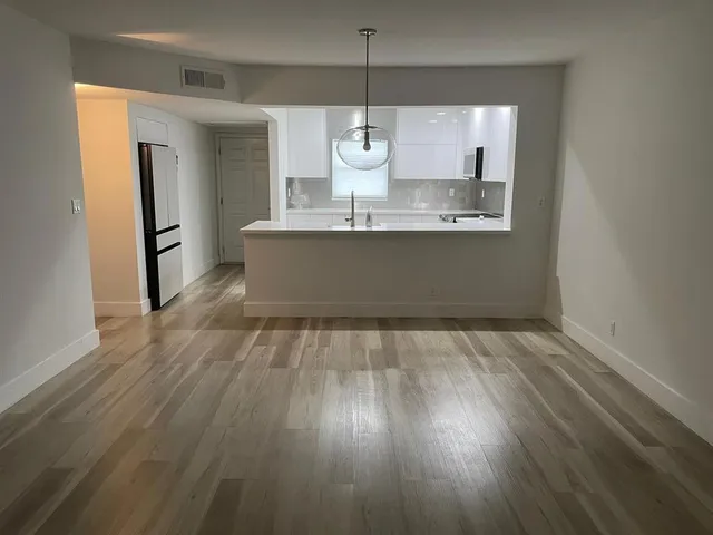 a view of kitchen with granite countertop cabinets and wooden floor