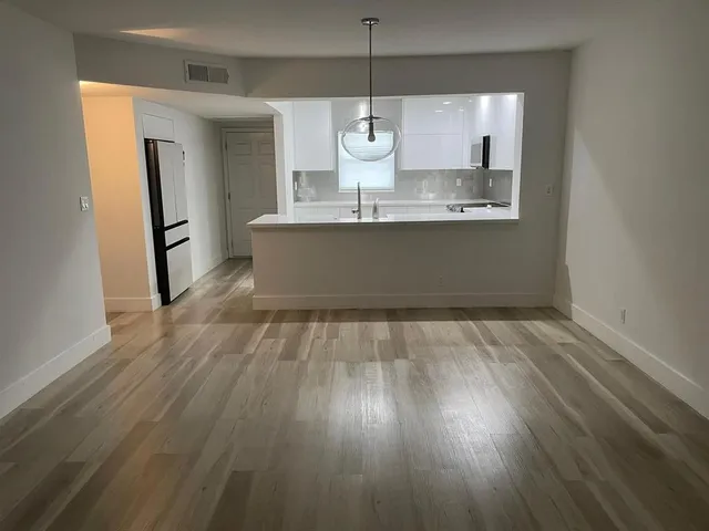 a view of kitchen with wooden floor and electronic appliances