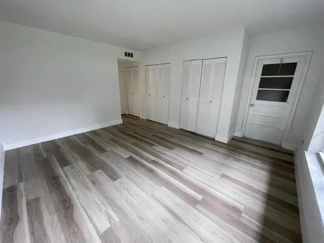 a view of a room with wooden floor
