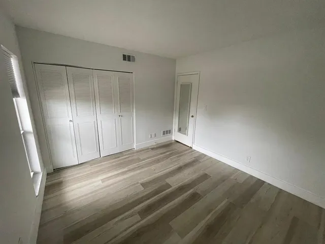a view of empty room with wooden floor