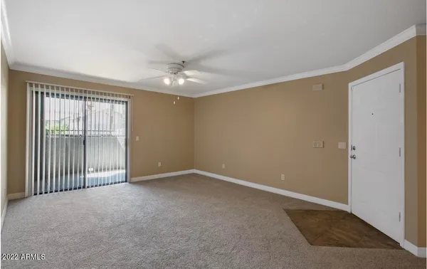 an empty room with a ceiling fan and a window