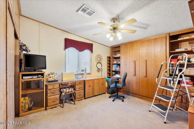 a view of a workspace with furniture and a window