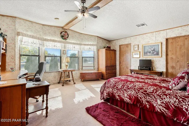 a bedroom with a bed couch and large window