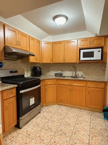 a kitchen with stainless steel appliances granite countertop a stove a sink and a microwave