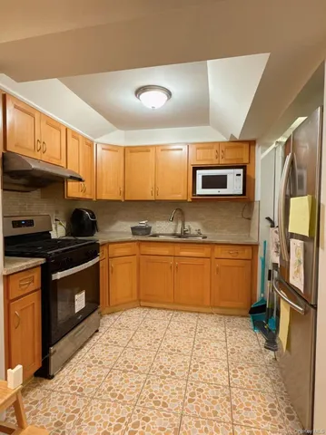 a kitchen with stainless steel appliances granite countertop a stove a sink and a microwave