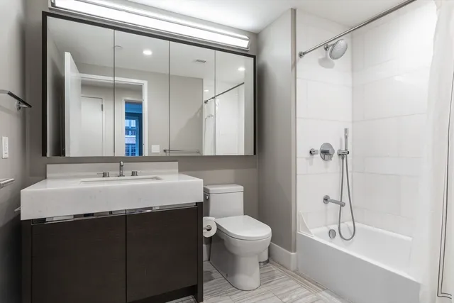 a bathroom with a granite countertop sink toilet and shower