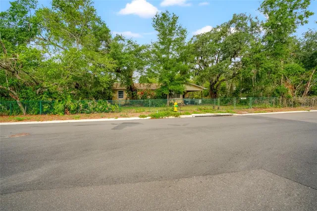a view of pool with large trees and a big yard with large trees