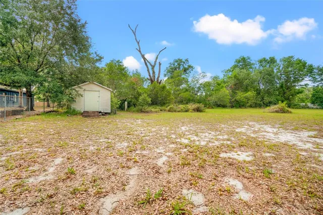 a view of a field with an trees in the background