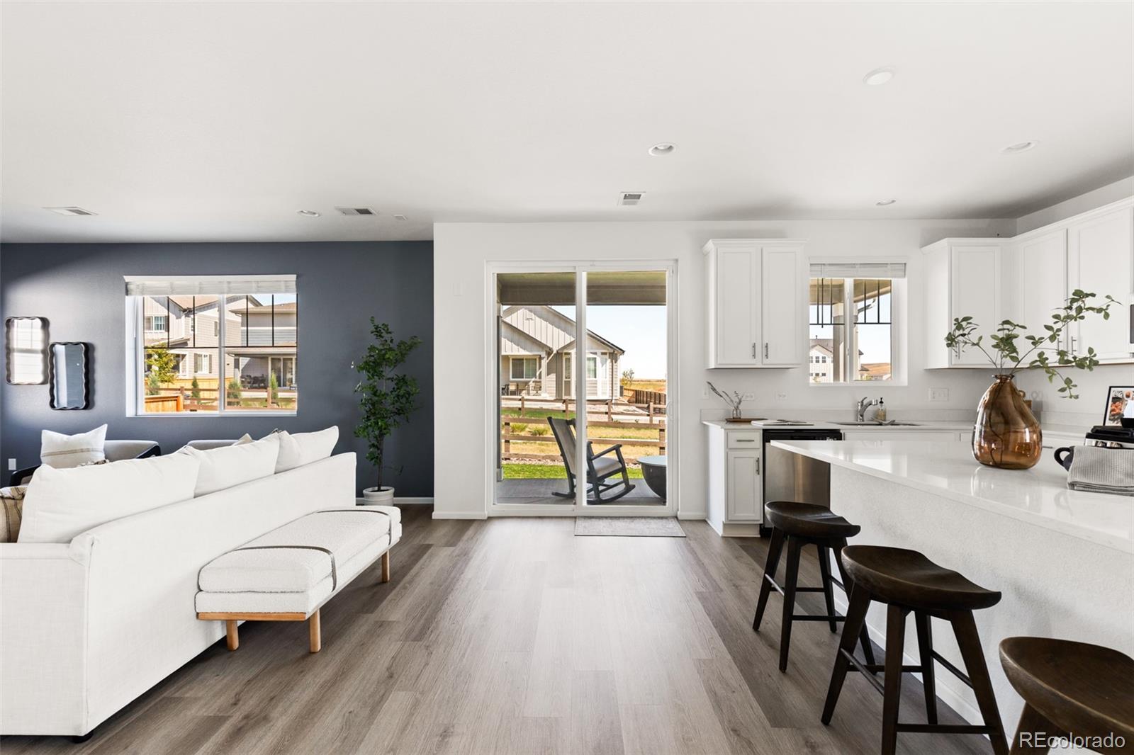 9054 Truckee Court Commerce City, CO 80022 - Photo 16 of 49 a living room with furniture a wooden floor and a large window