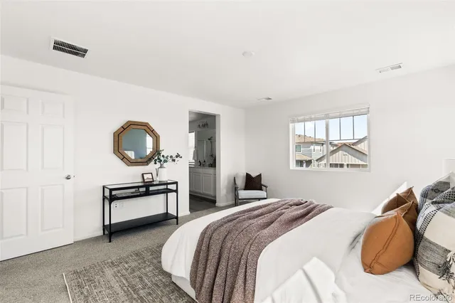 a bedroom with a bed and dresser with mirror