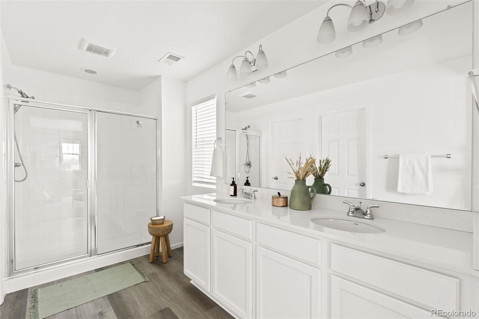 9054 Truckee Court Commerce City, CO 80022 - Photo 32 of 49 a bathroom with double vanity sink a mirror and a shower