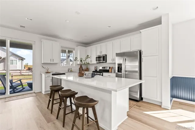 a kitchen with refrigerator and cabinets