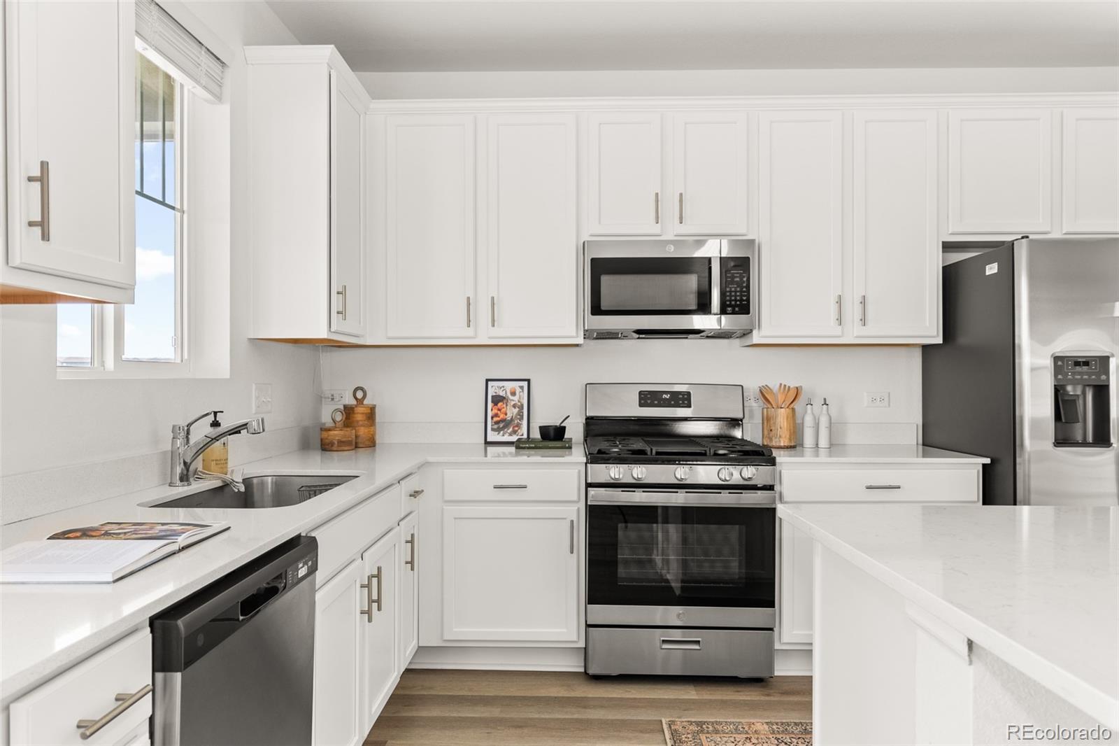 9054 Truckee Court Commerce City, CO 80022 - Photo 9 of 49 a kitchen with cabinets stainless steel appliances and sink