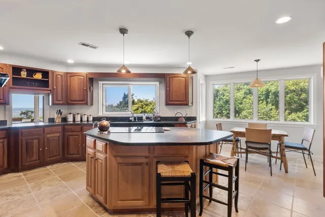 a kitchen with stainless steel appliances kitchen island granite countertop a sink and cabinets