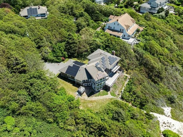 an aerial view of a house with a yard and large trees