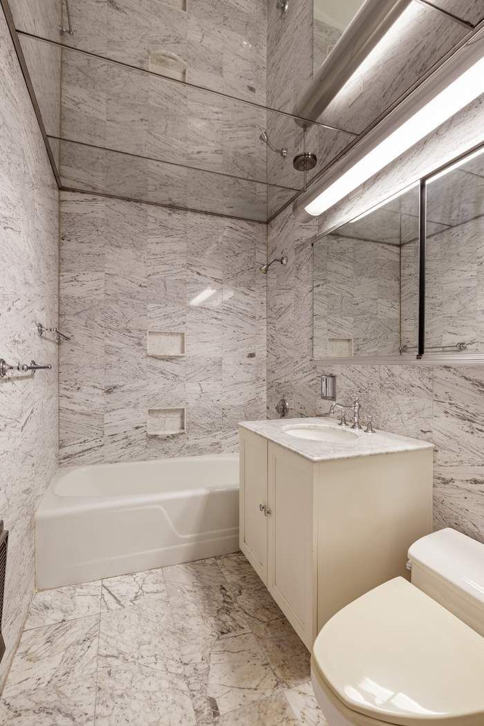 425 East 58th Street, Unit 21E Manhattan, NY 10022 - Photo 13 of 19 a bathroom with a sink a toilet and bathtub