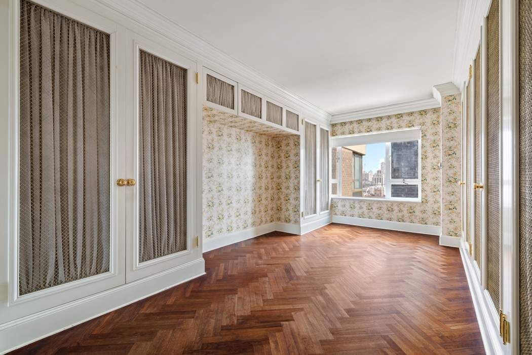 425 East 58th Street, Unit 21E Manhattan, NY 10022 - Photo 15 of 19 a view of an empty room with wooden floor and a window