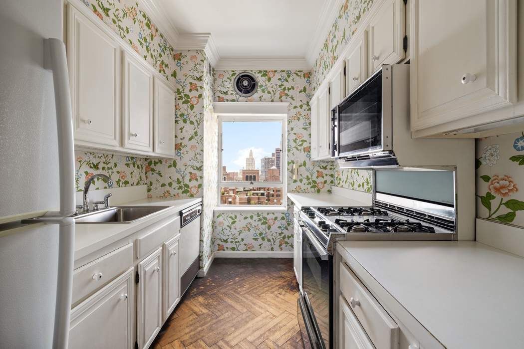 425 East 58th Street, Unit 21E Manhattan, NY 10022 - Photo 9 of 19 a kitchen with stainless steel appliances a stove a sink and a microwave
