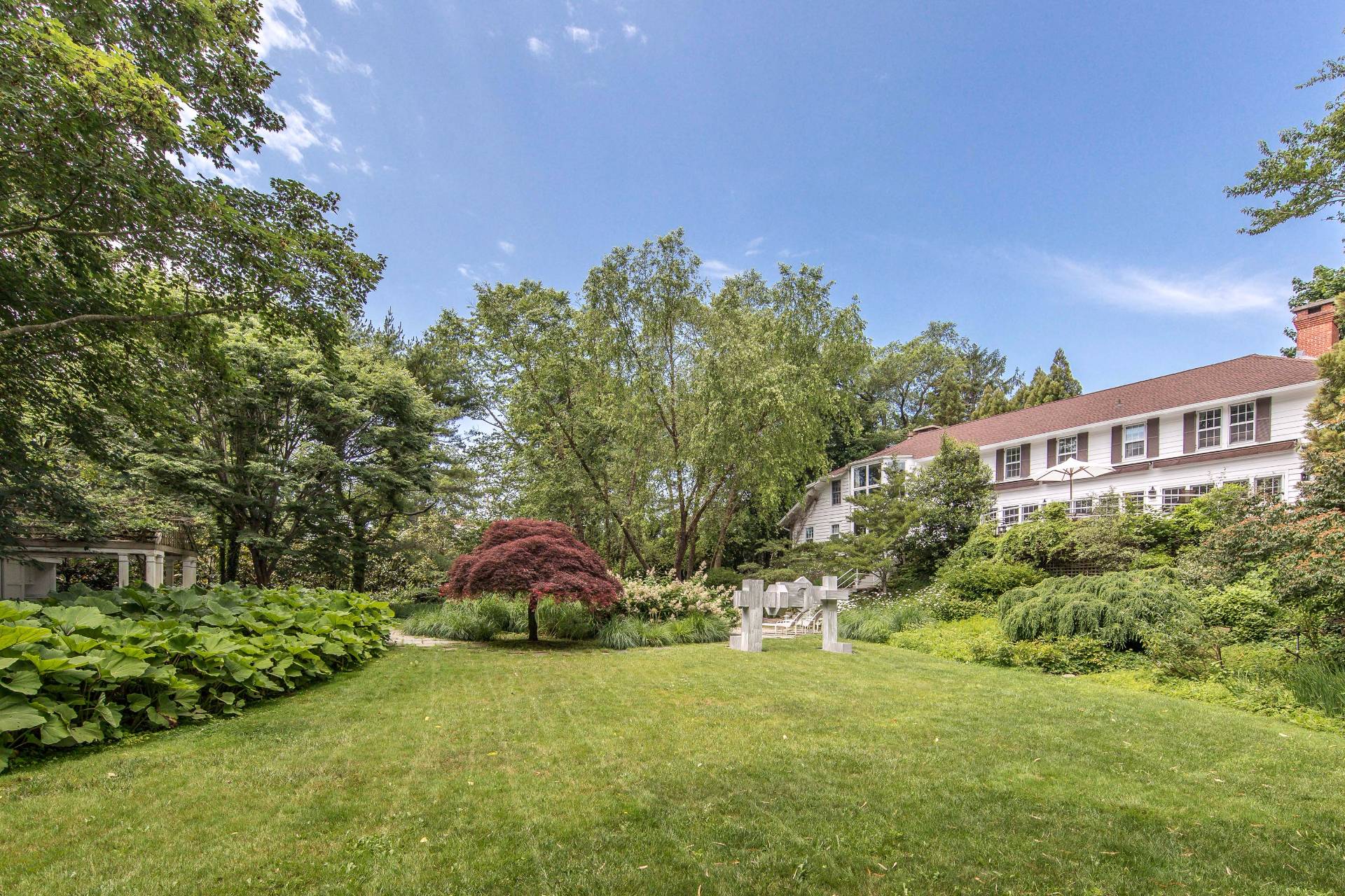 86 Georgica Road East Hampton, NY 11937 - Photo 2 of 20 a front view of a house with a yard and garage