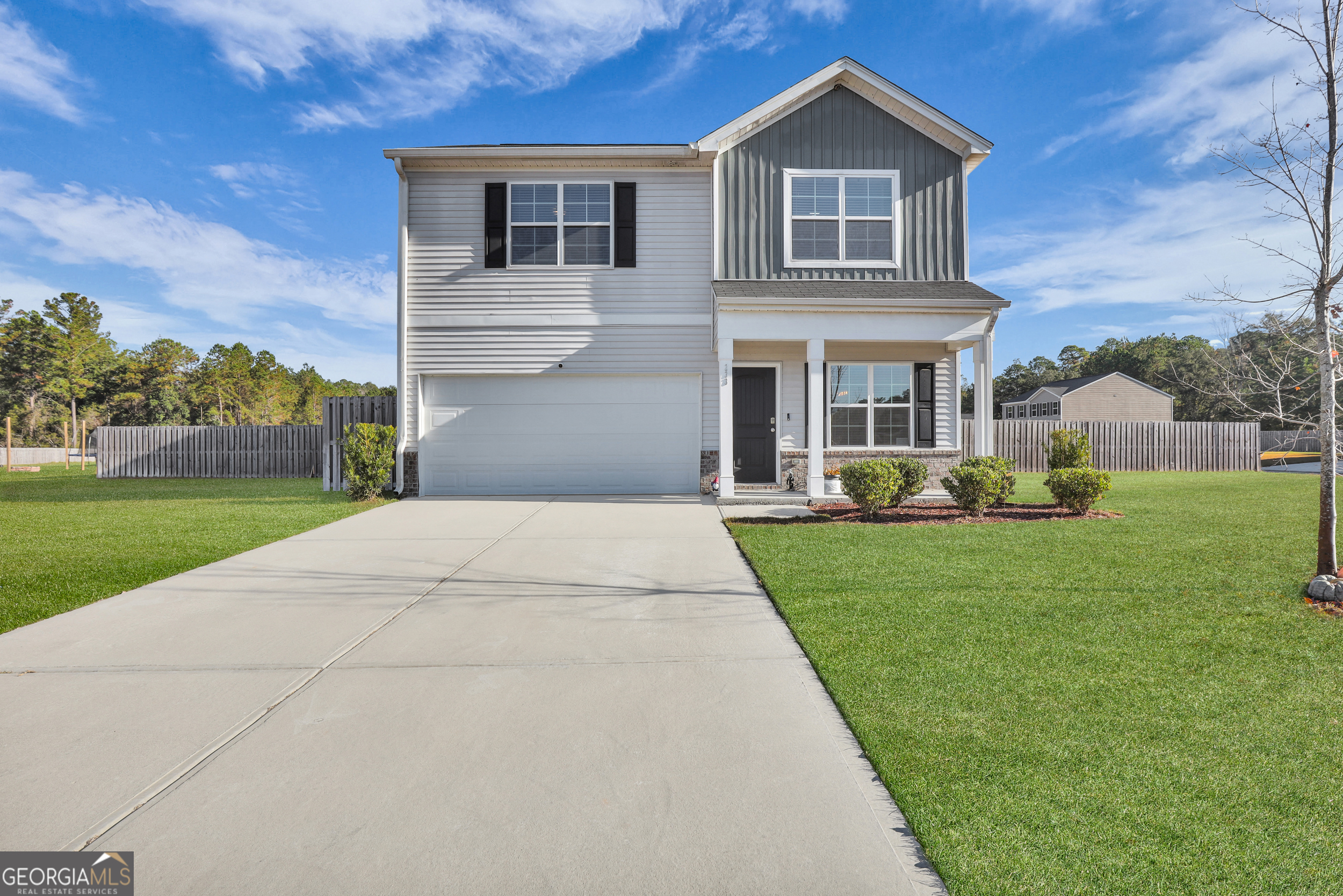 a front view of a house with a yard and potted plants