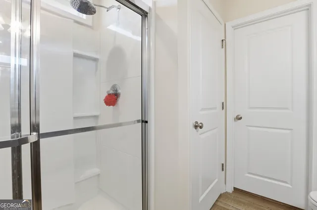 a bedroom with a bed and a black wall painting