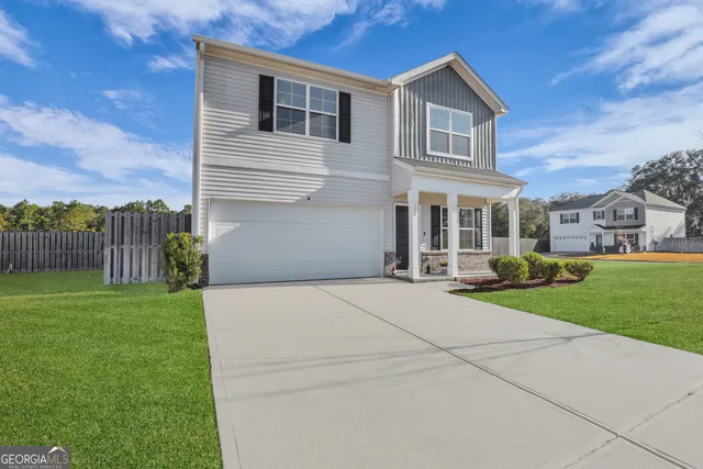 a front view of a house with a yard and trees