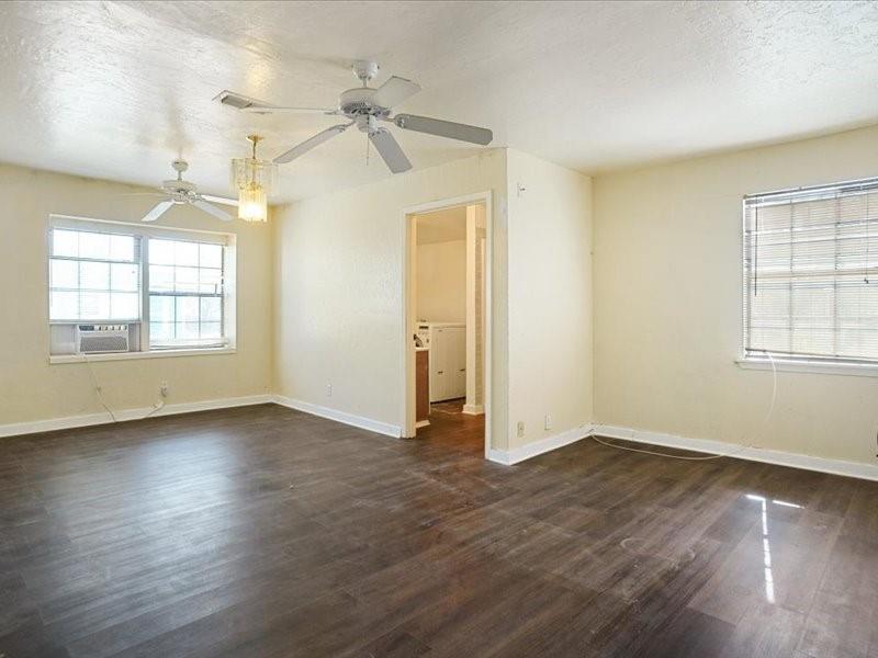 33 Park Lane Gainesville, TX 76240 - Photo 11 of 22 an empty room with wooden floor and windows