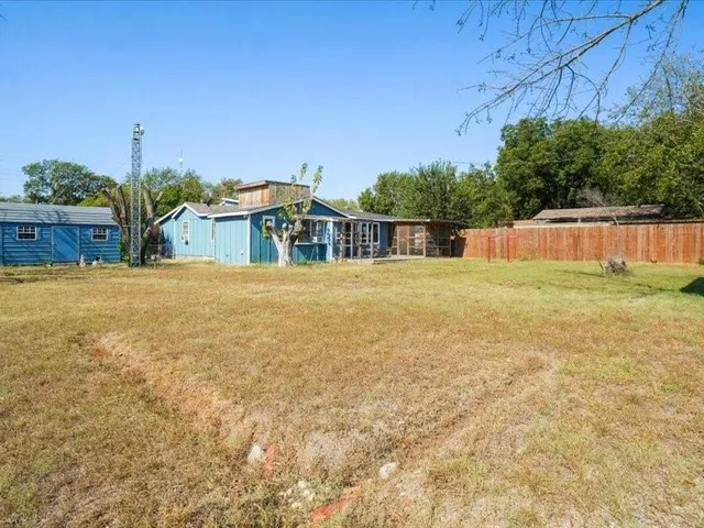 a view of an house with backyard and trees