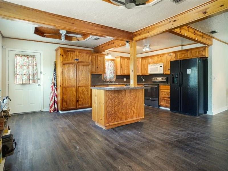 33 Park Lane Gainesville, TX 76240 - Photo 8 of 22 a view of a kitchen with wooden floor and a refrigerator