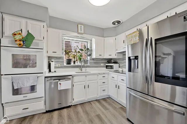 a kitchen with stainless steel appliances a refrigerator sink and microwave