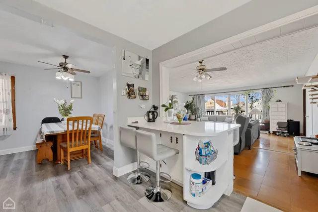 a living room with furniture and a dining table with wooden floor