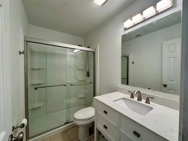 a bathroom with a sink toilet a mirror and shower