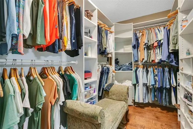 a view of walk in closet with clothes and shoes
