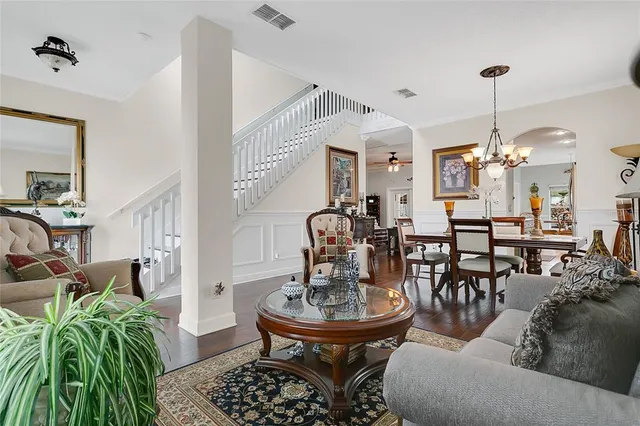 a living room with furniture a chandelier and a dining table