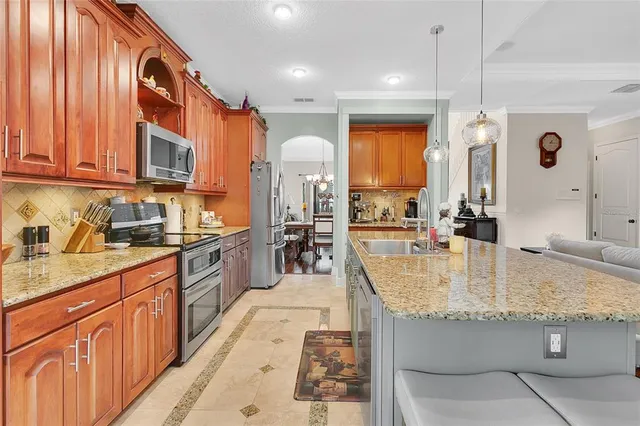 a large kitchen with kitchen island granite countertop a large counter top stainless steel appliances and cabinets