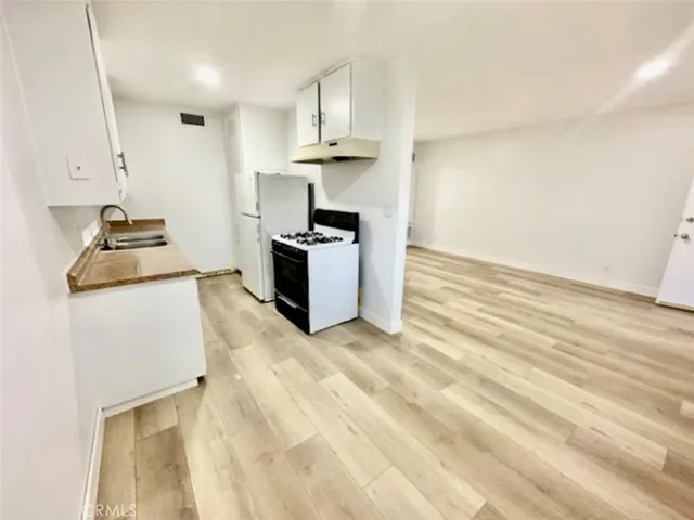 a kitchen with kitchen island granite countertop a sink cabinets stainless steel appliances and a counter space