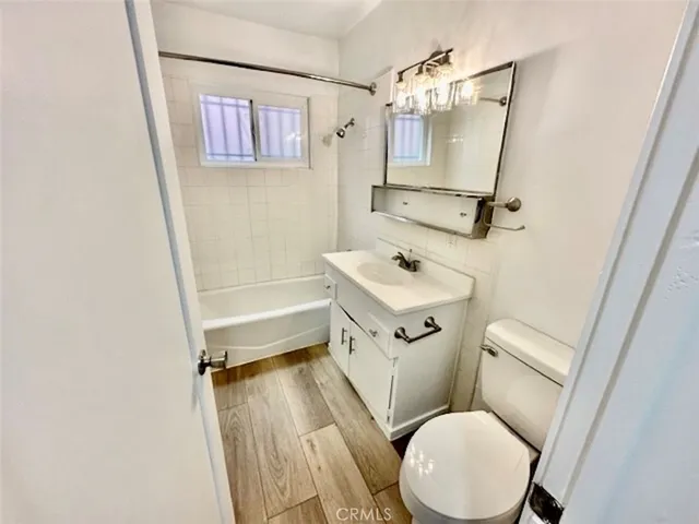 a bathroom with a sink a toilet a mirror and shower