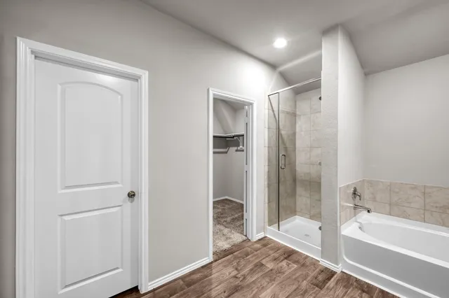 a bathroom with a tub shower and sink