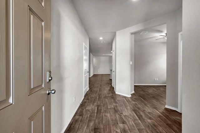 a view of a hallway with wooden floor and staircase