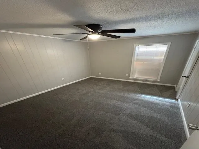 an empty room with windows and fan