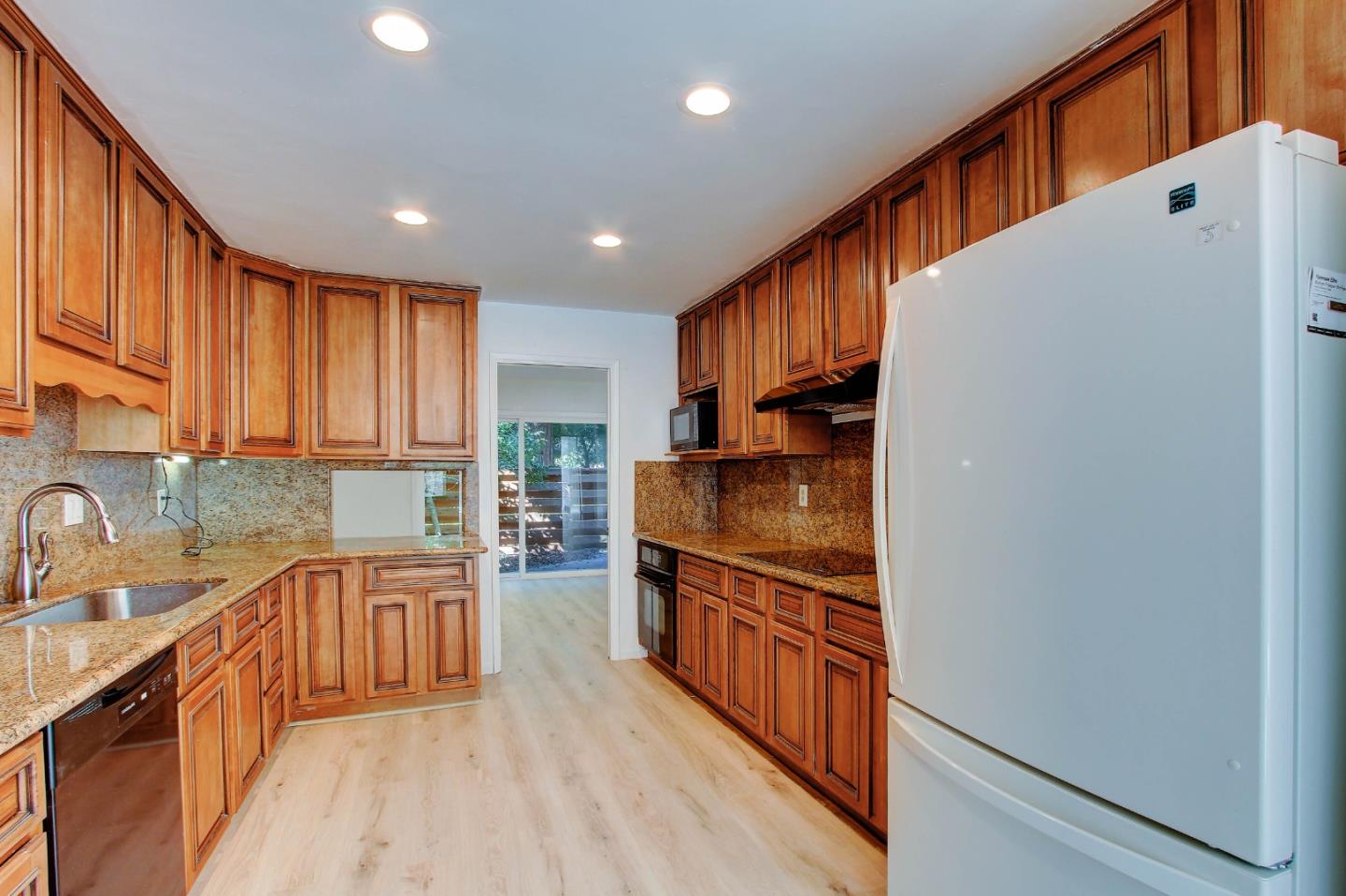 258 Paseo Bernal Moraga, CA 94556 - Photo 26 of 43 a kitchen with stainless steel appliances granite countertop a refrigerator a sink and wooden cabinets