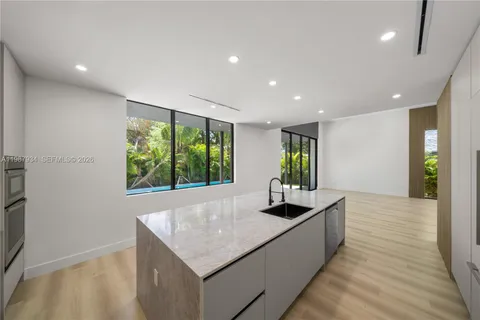 a kitchen with large windows and refrigerator