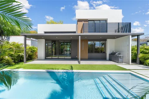 a view of swimming pool with lawn chairs and plants