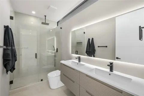 a bathroom with a shower sink and mirror