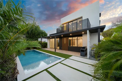 a view of a house with pool and sitting area